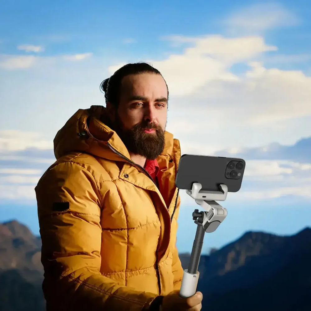 Person using Green Lion Palermo gimbal tripod stand outdoors for smartphone video recording