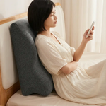Woman using Green Lion Relief Wedge Pillow for comfortable back support while reading in bed